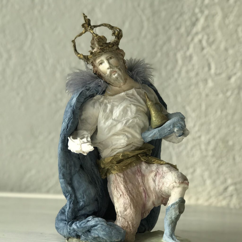 a second king is kneeing on his nee among the other nativity characters